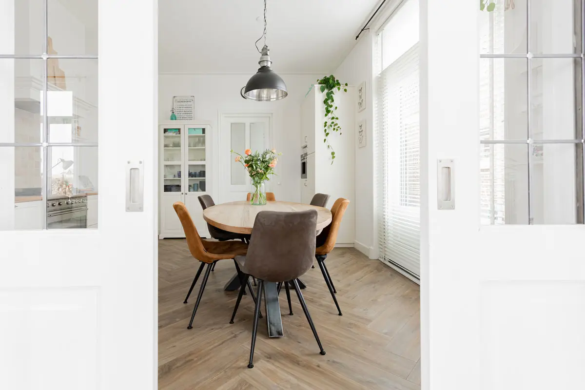 Eetkamer met ronde tafel en suitedeuren in een woning in Groningen
