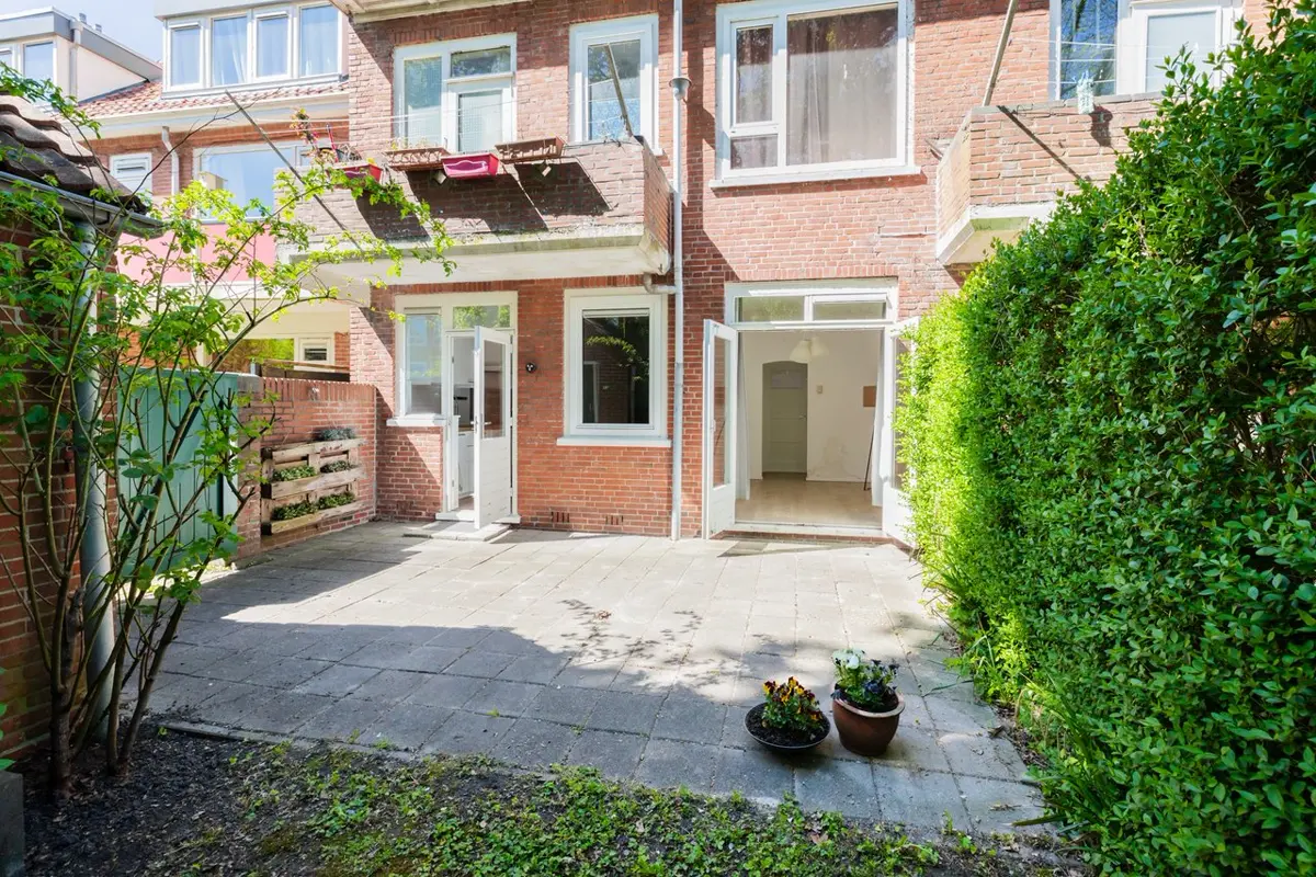 Kaal terras met tegels achter een jaren dertig woning