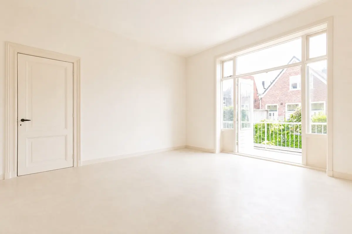 Dezelfde kamer digitaal leeggemaakt met lichte vloer en witte wanden
