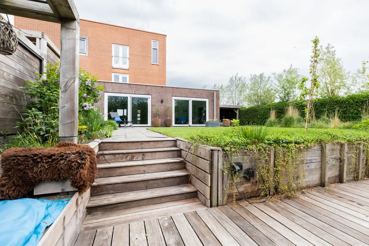Tuin met vlonder onder een grauwe hemel